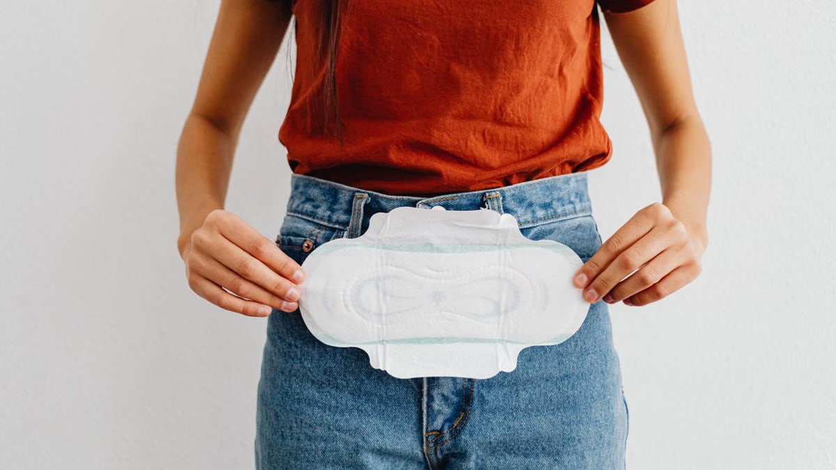 A woman showing a sanitary pad, highlighting menstrual health and hygiene.